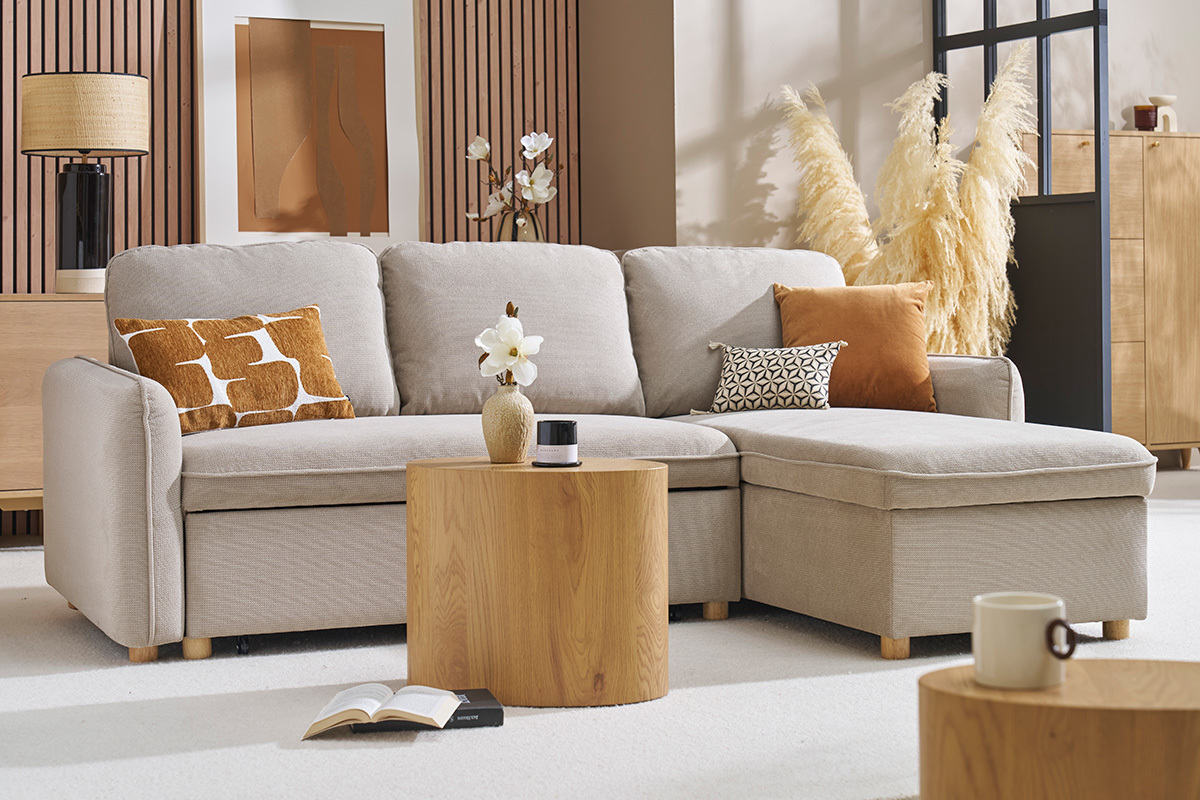 Canap� d'angle convertible beige avec coffre, coussins d�coratifs, table basse en bois, salon moderne.