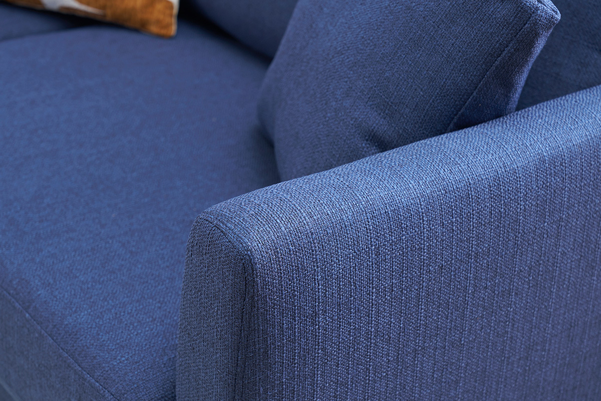 Gros plan sur l'accoudoir du canap� scandinave en tissu bleu fonc�.