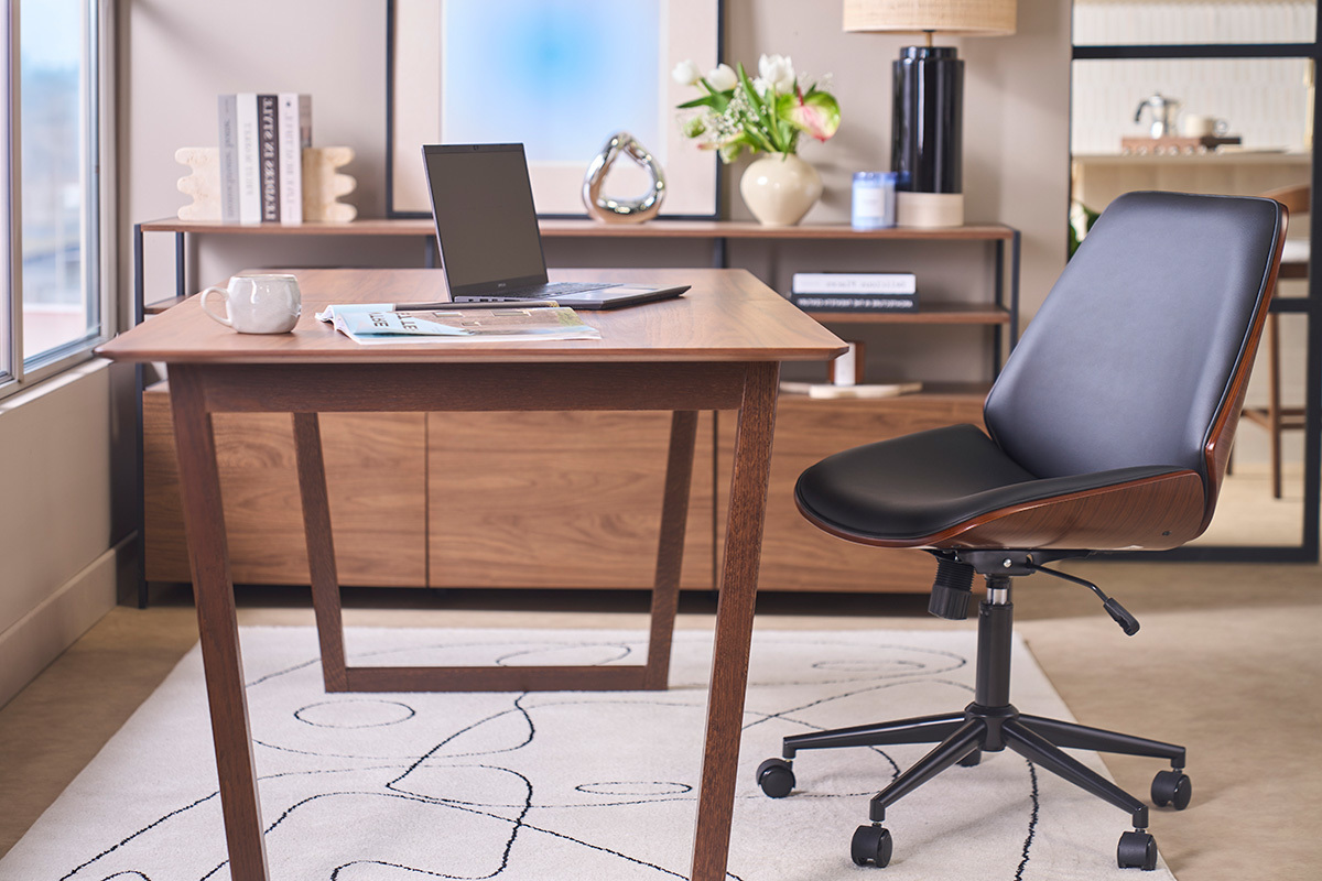 Chaise de bureau � roulettes noire et bois fonc� DOUGLAS pr�s d'un bureau en bois, vue de profil.