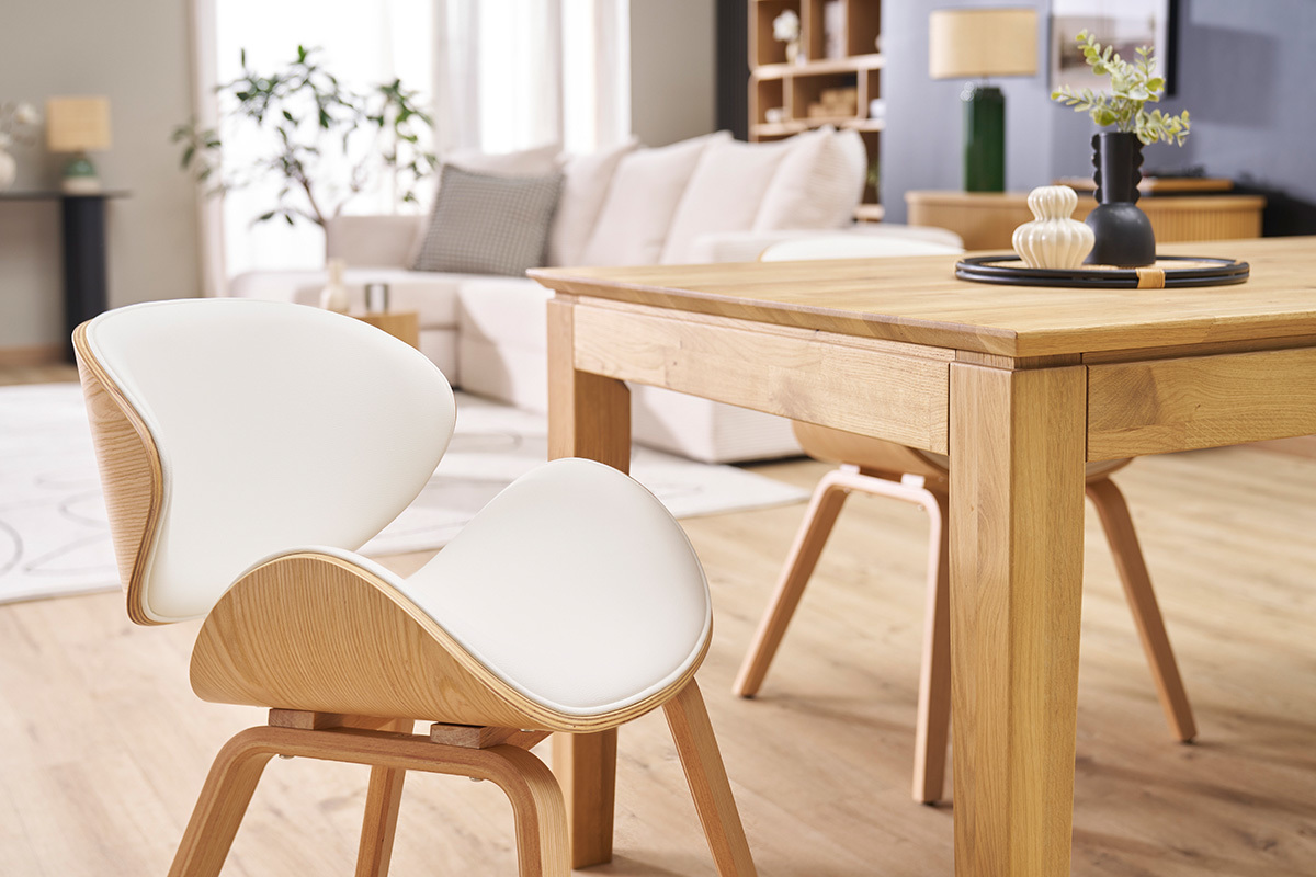 Chaise design blanc et bois clair WALNUT pr�s d'une table en bois, vue de profil dans un salon.
