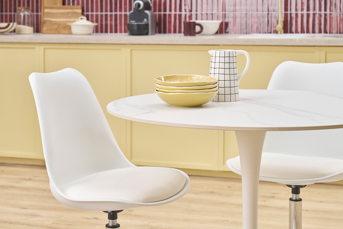 Chaise pivotante blanche STEEVY V2 pr�s d'une table, vue int�rieure de cuisine.