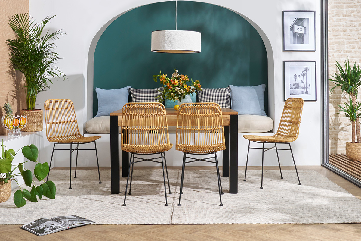 Chaises en rotin et m�tal noir autour d'une table en bois dans un d�cor int�rieur.