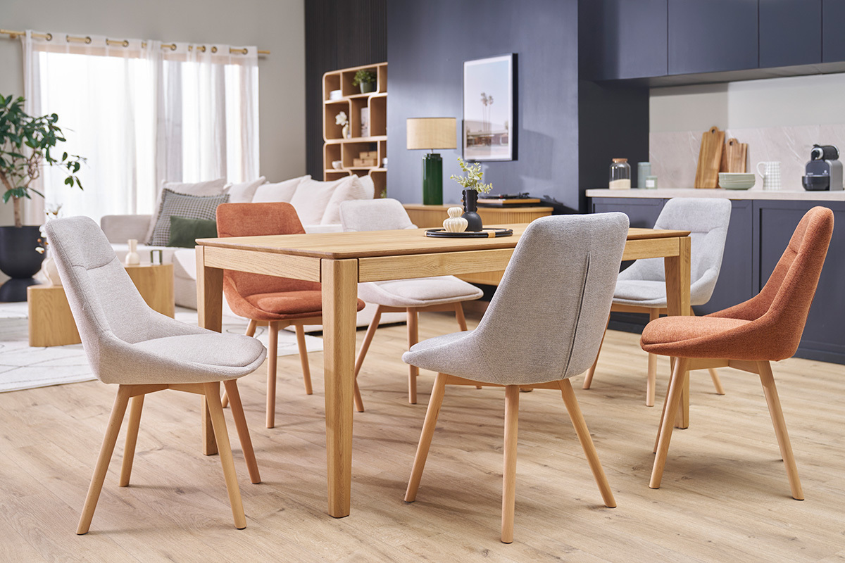 Chaises en tissu et bois autour d'une table en bois clair dans une salle � manger moderne.