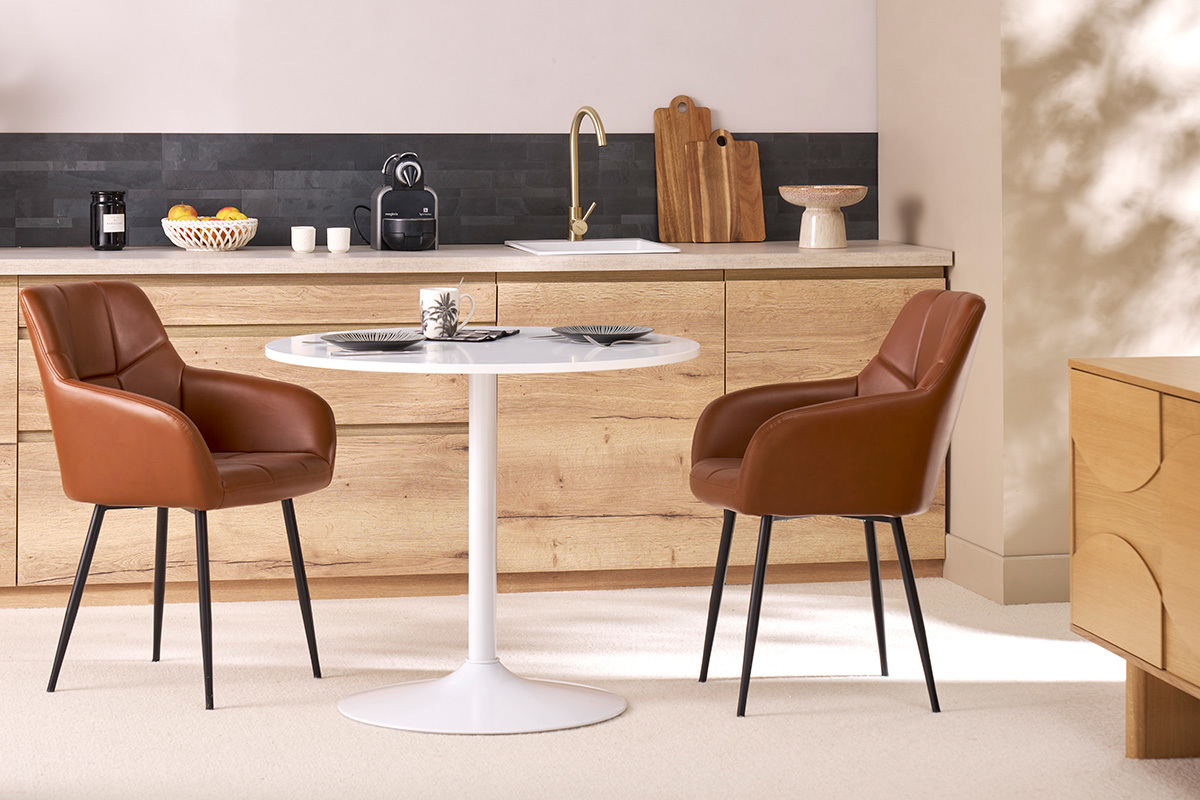 Chaises matelass�es marron et m�tal noir MONTERO autour d'une table blanche.