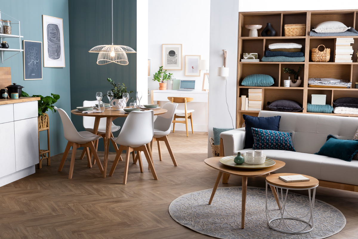 Chaises scandinaves blanches et bois autour d'une table ronde.