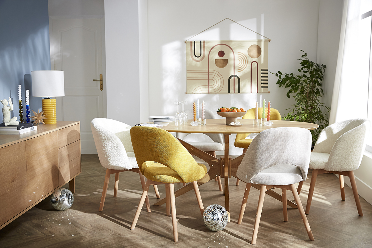 Chaises scandinaves jaunes et blanches autour d'une table en bois clair.