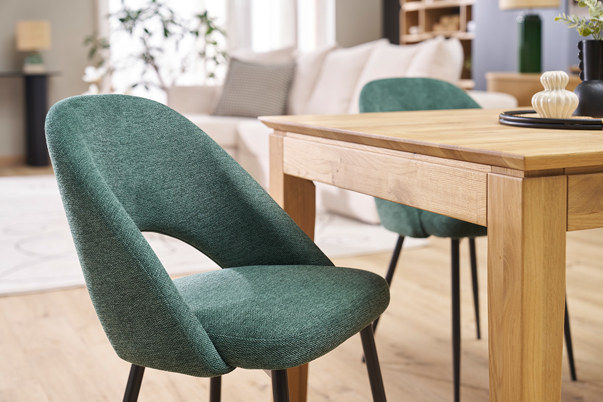 Chaises en tissu vert et m�tal noir pr�s d'une table en bois dans un salon.