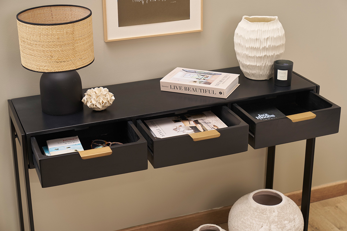 Console noire avec trois tiroirs ouverts, vue de dessus, objets d�coratifs pos�s sur le dessus.