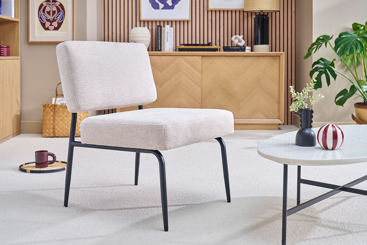 Fauteuil en tissu chenille beige et m�tal noir dans un salon moderne.