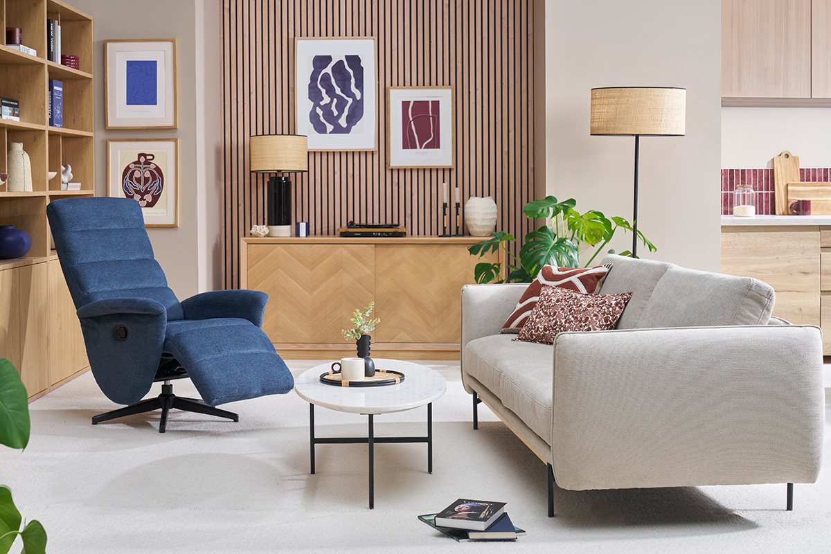 Salon avec fauteuil pivotant relax en tissu bleu et canap� clair.
