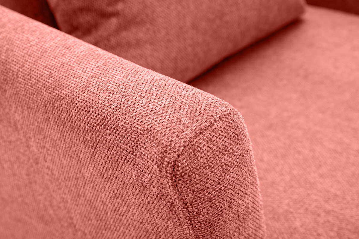 Gros plan sur l'accoudoir d'un fauteuil en tissu effet velours textur� terracotta.