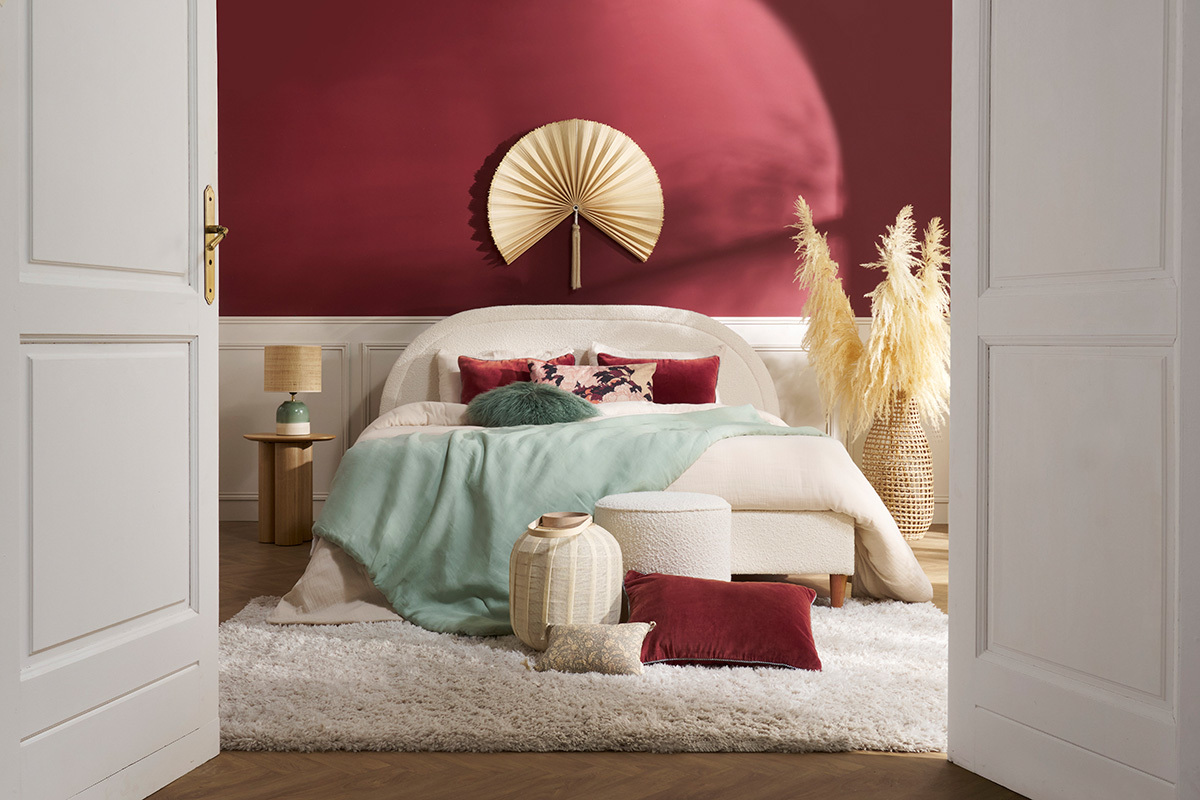 Lit 2 places CHARLINE en tissu boucl� blanc avec coussins et d�coration dans une chambre.