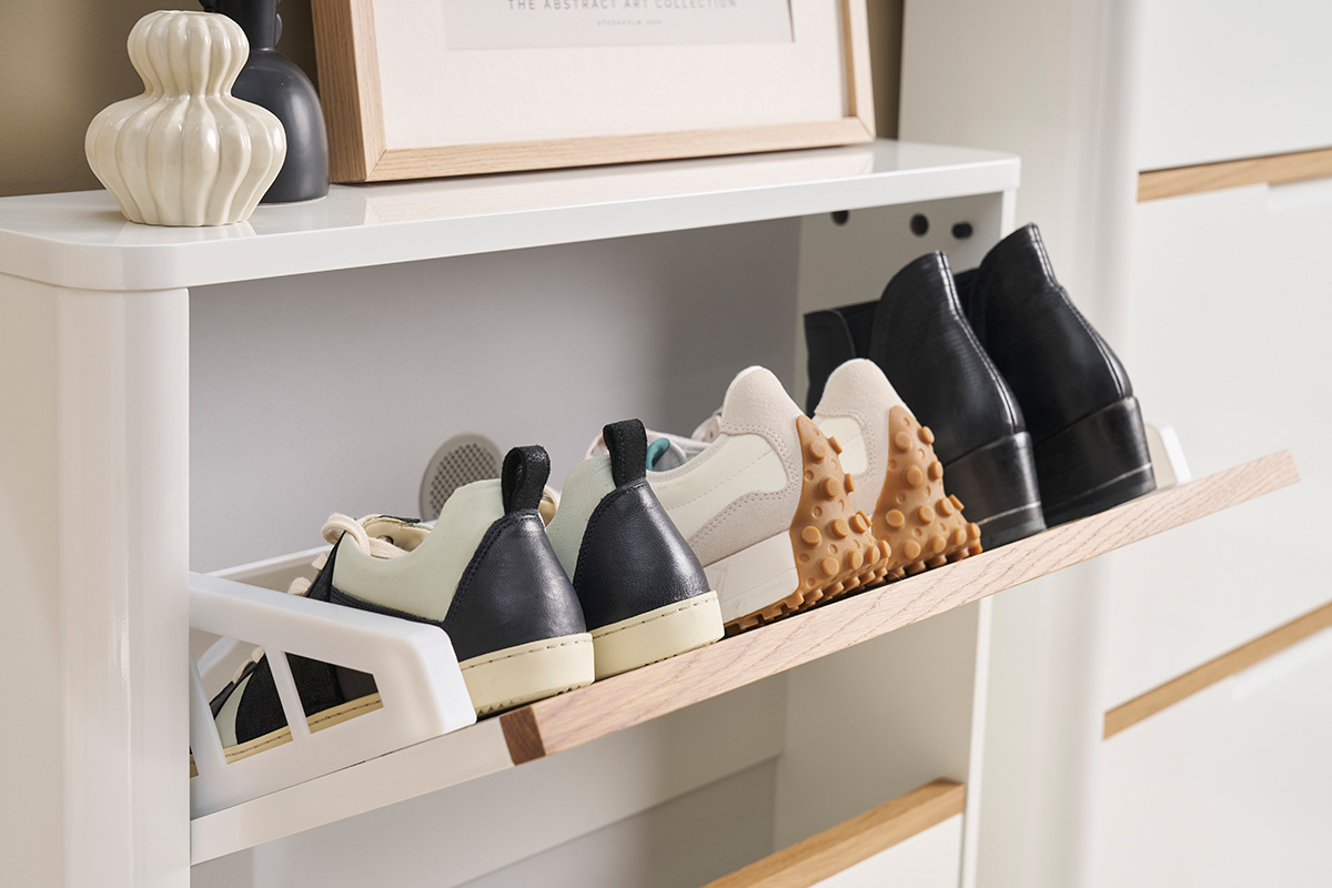 Meuble � chaussures blanc laqu� avec abattant ouvert, chaussures rang�es.