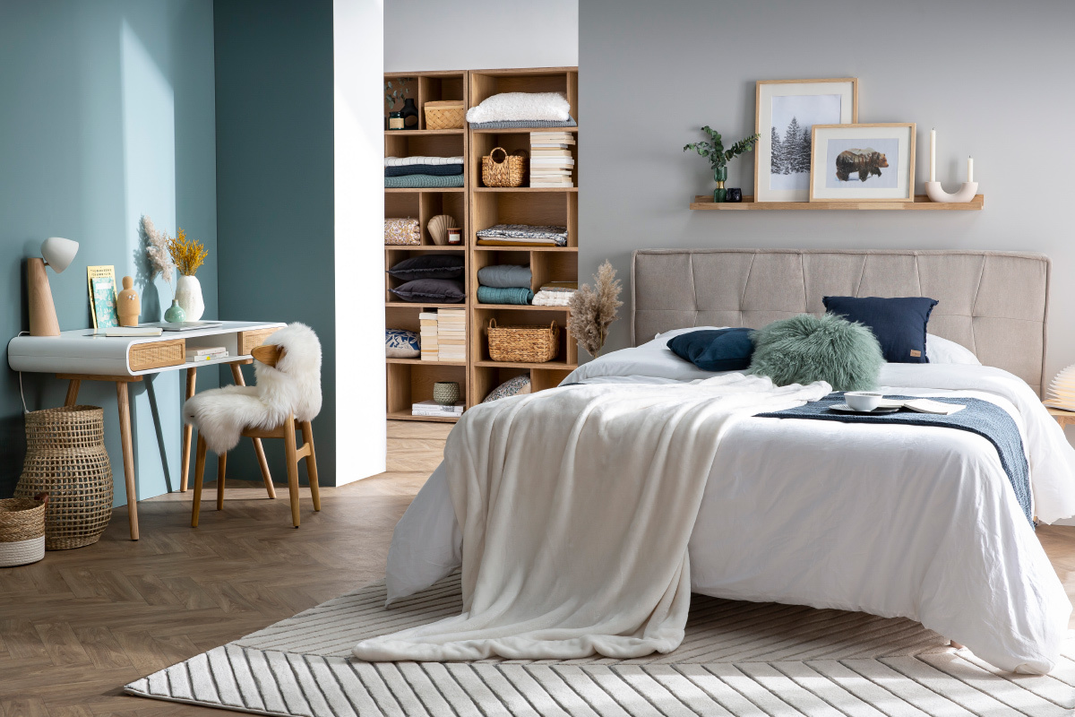Chambre moderne avec �tag�re murale en bois clair au-dessus du lit, d�cor�e de cadres et bougeoirs.