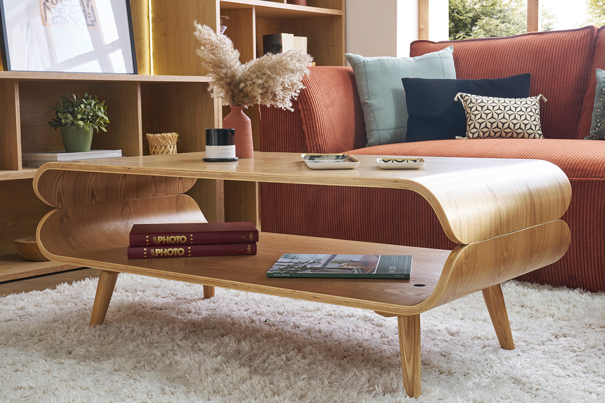 Table basse scandinave bois clair avec espace de rangement, devant un canap� rouge.