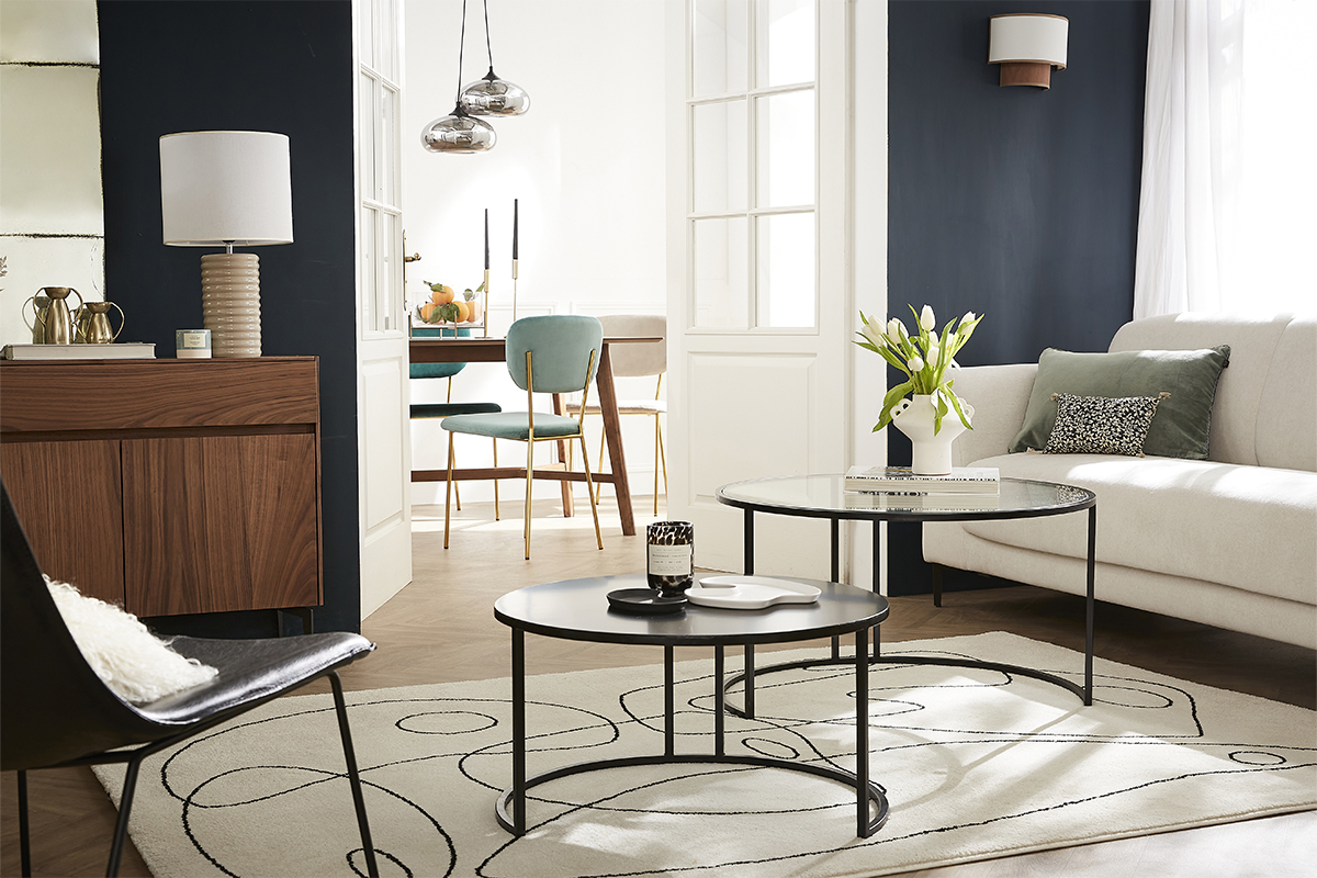 Tables basses gigognes rondes en verre tremp� et m�tal noir dans un salon moderne.