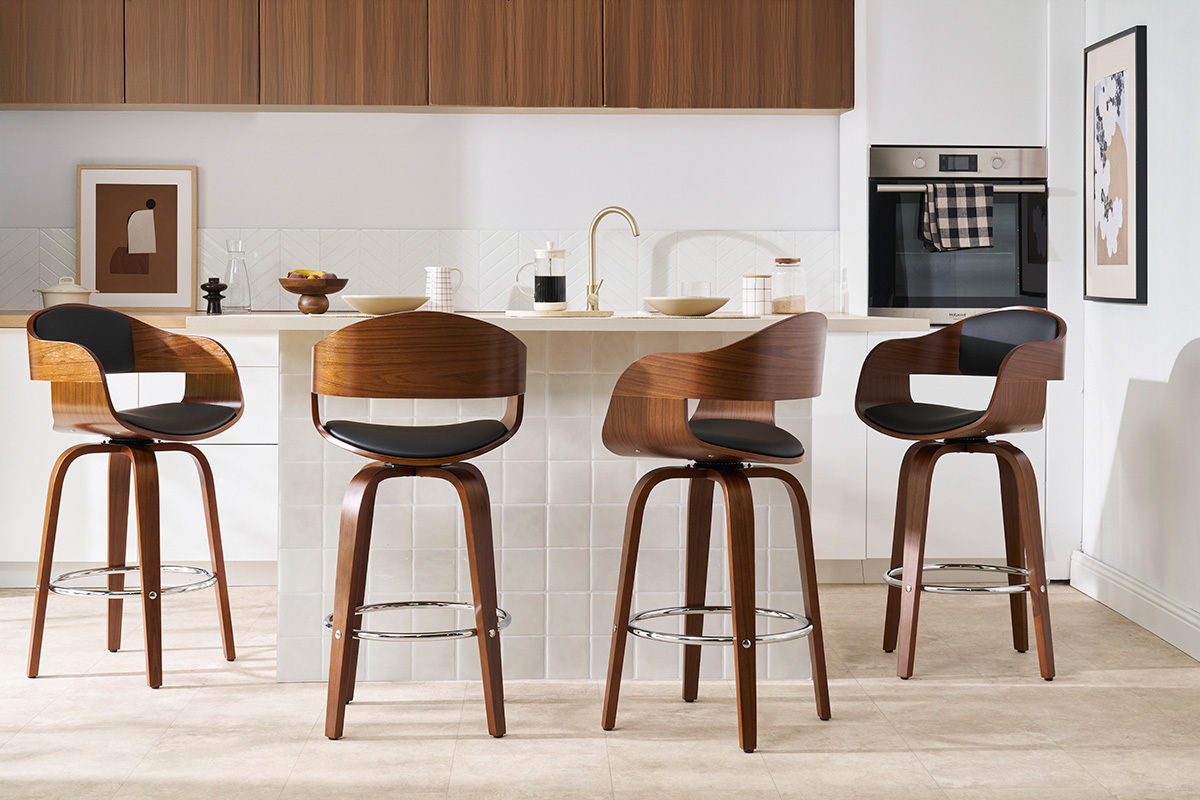 Quatre tabourets de bar en bois fonc� et noir devant un �lot de cuisine.