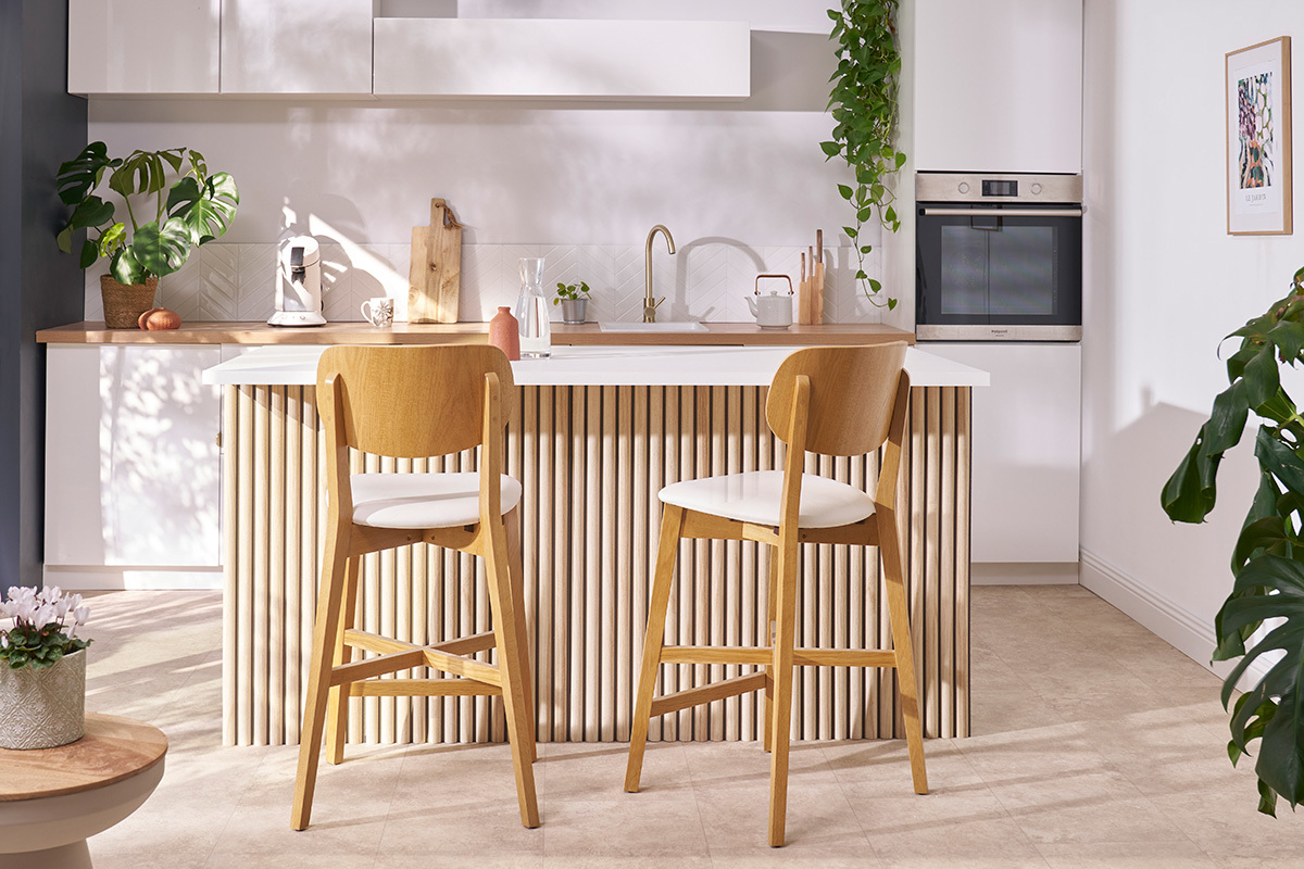 Tabouret de bar LUCIA bois clair dans une cuisine moderne, vue de face.
